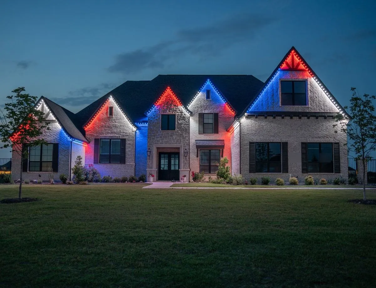 Home with red, white and blue gable lighting at dusk